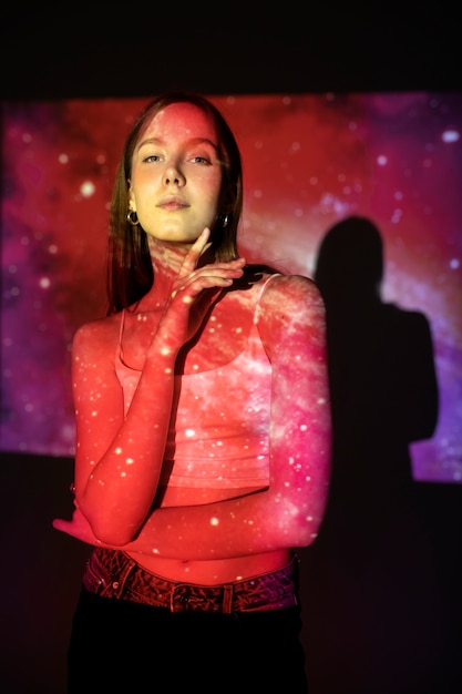 Young woman standing in universe texture projection