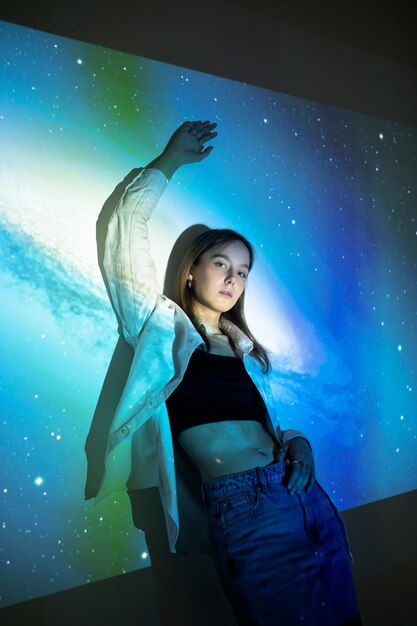 Young woman standing in universe texture projection