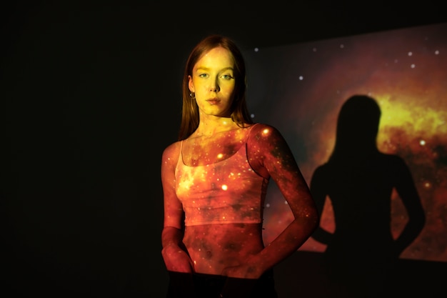 Young woman standing in universe texture projection