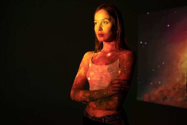 Young woman standing in universe texture projection