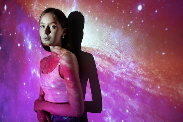 Free photo young woman standing in universe texture projection