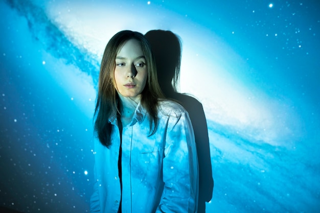 Young woman standing in universe texture projection