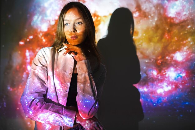 Young woman standing in universe texture projection