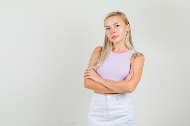 Young woman standing with crossed arms in singlet