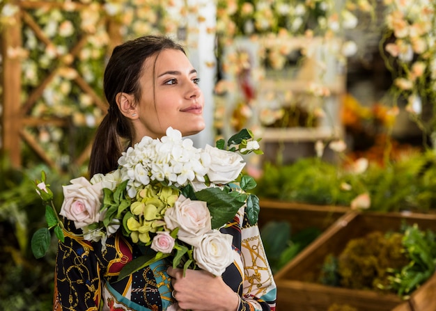 Free photo young woman standing with flowers bouquet