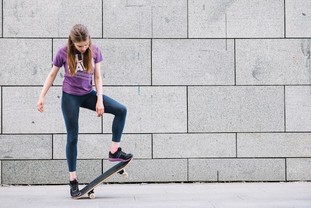 Young woman standing with skateboard