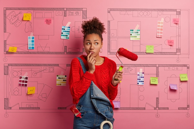 Free photo young woman stands next to house design sketch ready for renovation