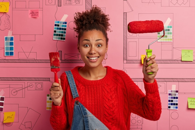 Free photo young woman stands next to house design sketch ready for renovation