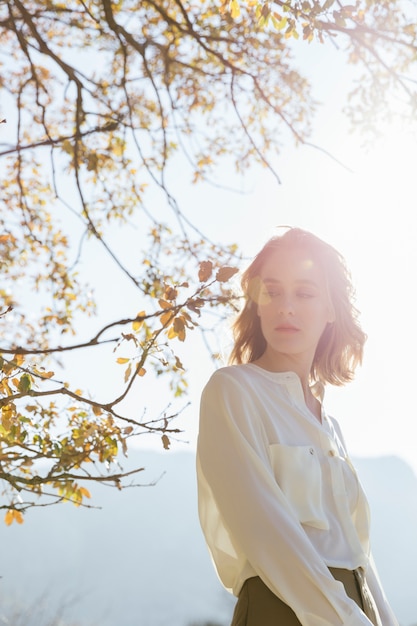 Free photo young woman staring under sunlight