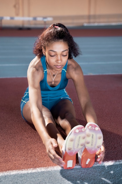 Young woman stretching legs full shot