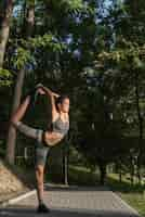 Free photo young woman stretching in the park