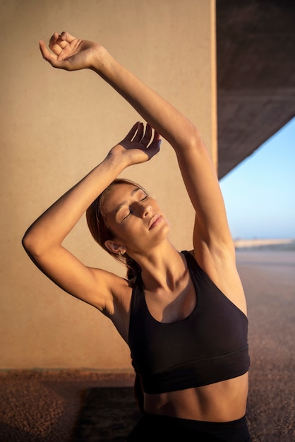 Young woman stretching and preparing for exercise outdoors