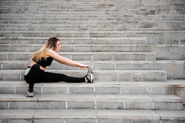 Young woman stretching at the street