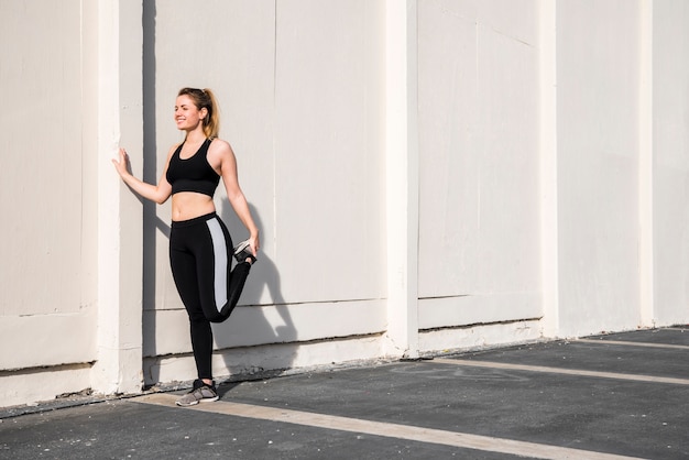 Young woman stretching at the street