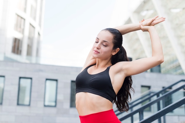 Young woman stretching in the street