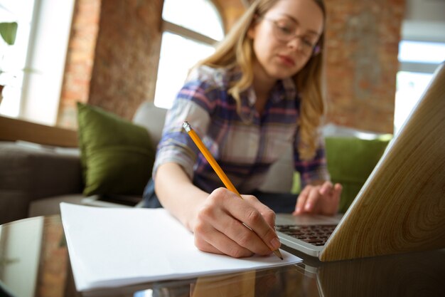 Young woman studying at home during online courses or free information by herself making notes