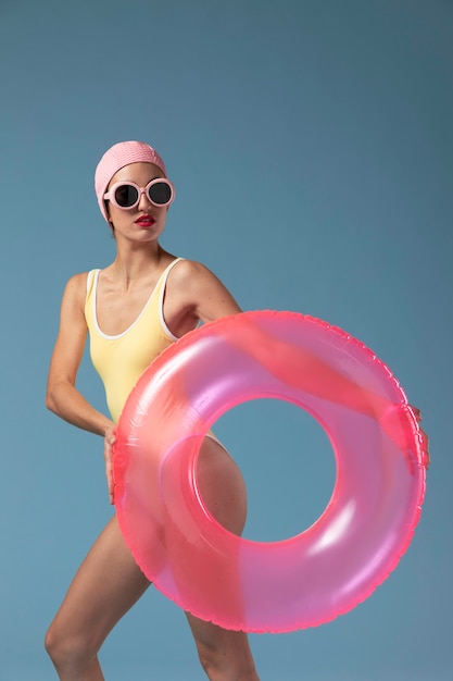 Free Photo young woman in swimsuit with a swimming ring