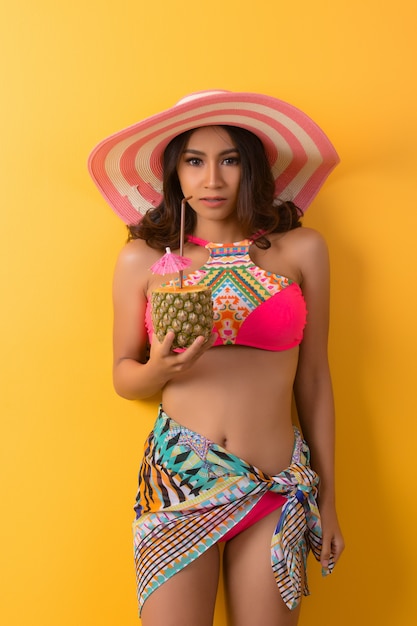 young woman in swimwear isolated over yellow