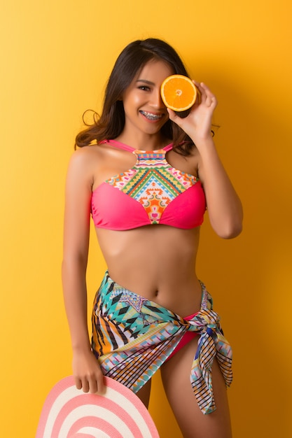 young woman in swimwear isolated over yellow