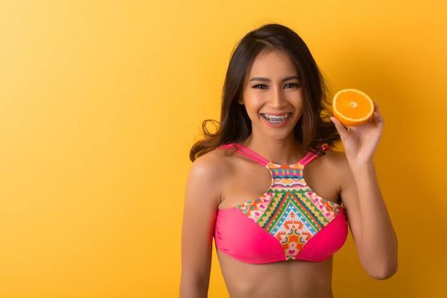 Free photo young woman in swimwear isolated over yellow