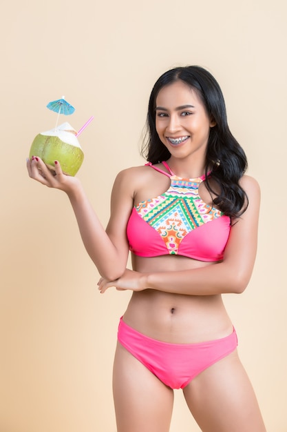 Free photo young woman in swimwear with coconut