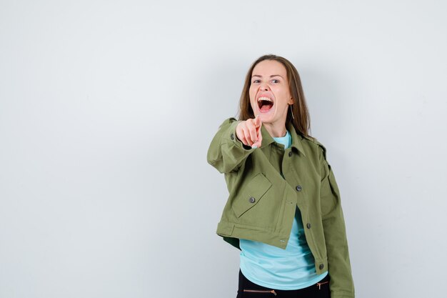 Free Photo young woman in t-shirt, jacket pointing forward and looking energetic , front view.