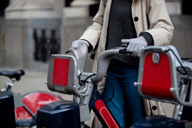 Young woman taking a bike to ride it in the city