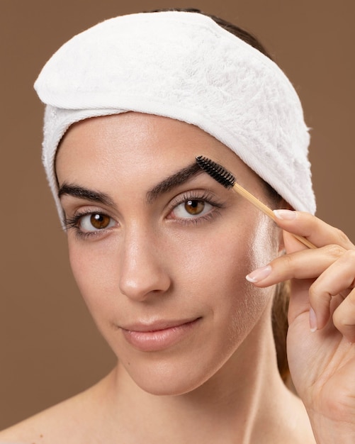 Young woman taking care of her eyebrows