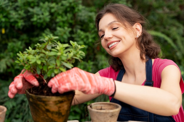 Free photo young woman taking care of her plants in a greenhouse