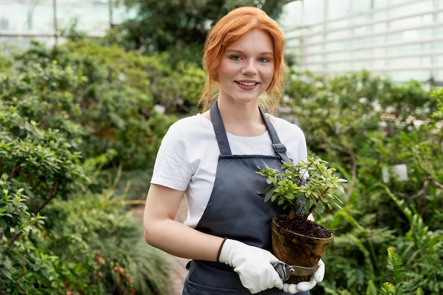 Young woman taking care of her plants in a greenhouse