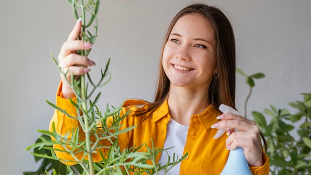 Free photo young woman taking care of her plants at home