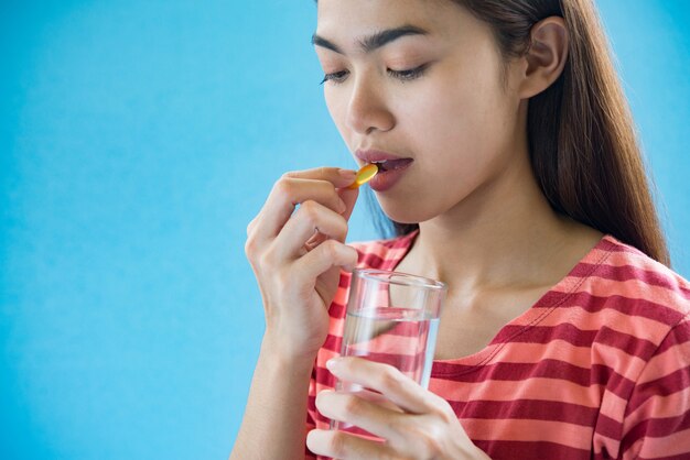 Young woman taking medicine pill after doctor order