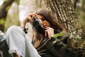 Free photo young woman taking photo in nature