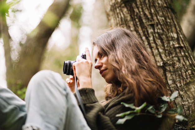 Free Photo young woman taking photo in nature