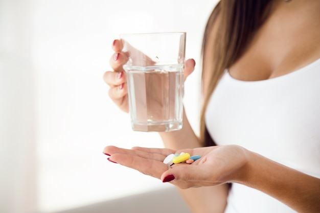 Free photo young woman taking pills at home.