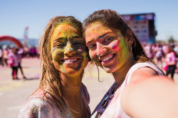 Young woman taking selfie with her female friend