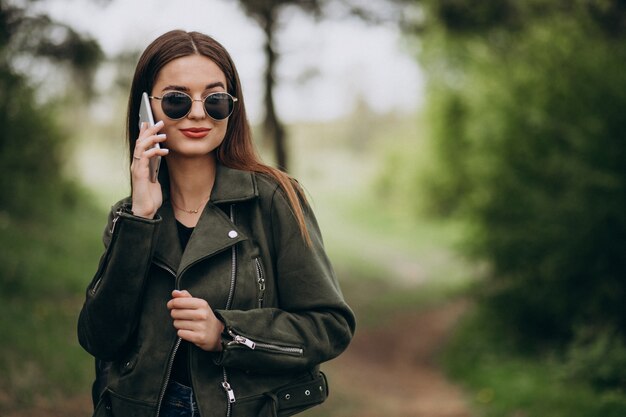 Young woman talkimng on the phone in park