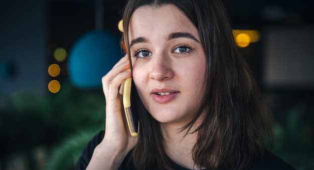 A young woman talking on the phone closeup blurred background