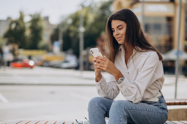 Young woman talking on the phone outside the street