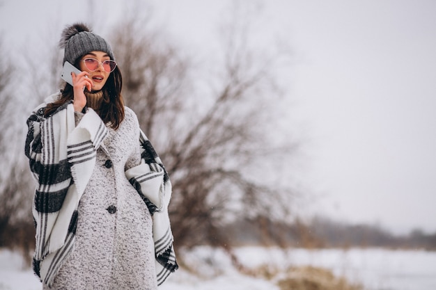 Young woman talking on phone outside in winter park