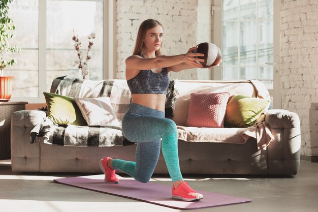 Young woman teaching at home online courses of fitness aerobic sporty lifestyle while being quarantine