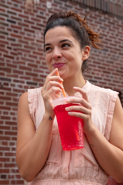 Young woman tolerating the heat wave with a cool drink