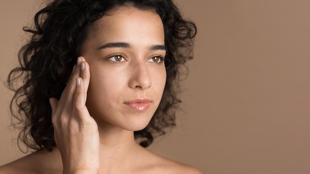 Young woman touching her face