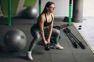 Free photo young woman training at the gym with equipment