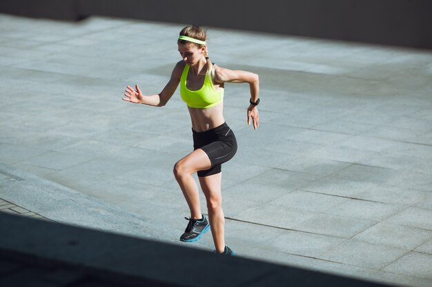 Young woman training outdoors in autumn sunshine. Concept of sport, healthy lifestyle,