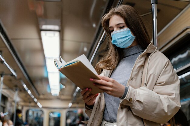 Young woman travelling by subway reading a book