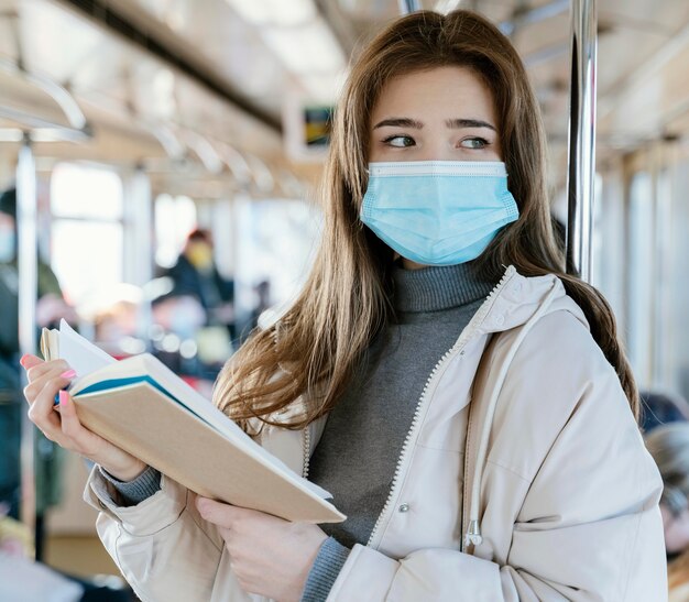 Young woman travelling by subway reading a book