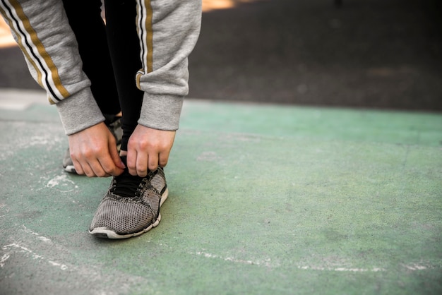 Free Photo young woman tying her sneakers