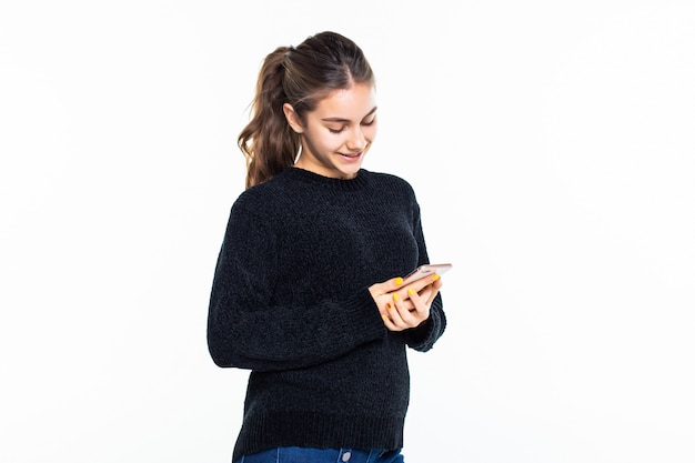 Young woman use of the cellphone isolated on white wall