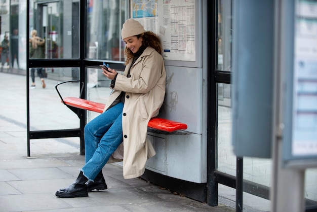 Free photo young woman using her smartphone in the city